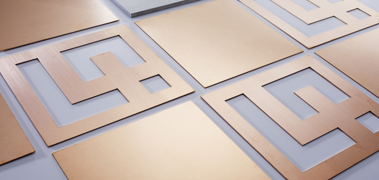 Rechteckige Kupfer Laserzuschnitte in unterschiedlichen Blechdicken liegen nebeneinander