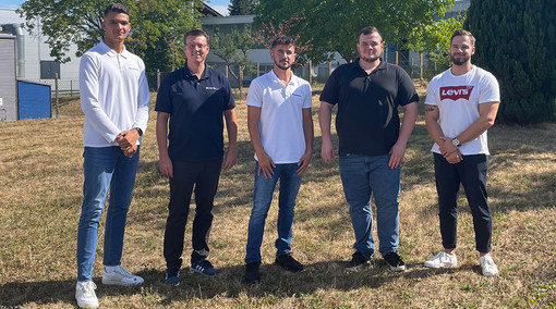 5 neue Mitarbeiter stehen auf einer Wiese