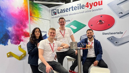 Gruppenfoto von 4 Mitarbeiterinnen und Mitarbeitern auf dem Laserteile4you Messestand
