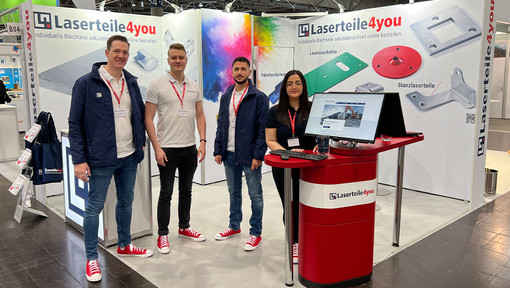 Gruppenfoto von 4 Mitarbeiterinnen und Mitarbeitern auf dem Laserteile4you Messestand