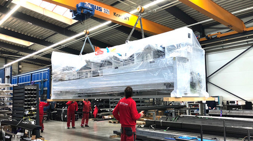 Teile einer neuen Rohrlaseranlange werden an einem Kran hängend angeliefert