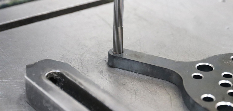 Detailfoto einer Reibahle die in eine Bohrung eines Metallteils bewegt wird